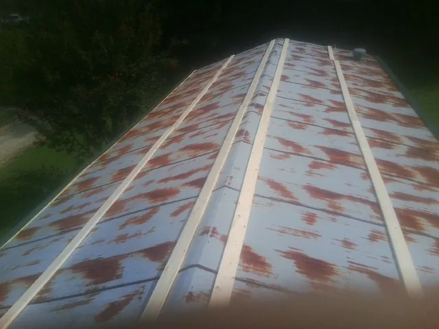 Rusted metal roof panels with new wood purlins before replacement — Storm Damage Roof Repair in Roscoe by Roofing Brothers