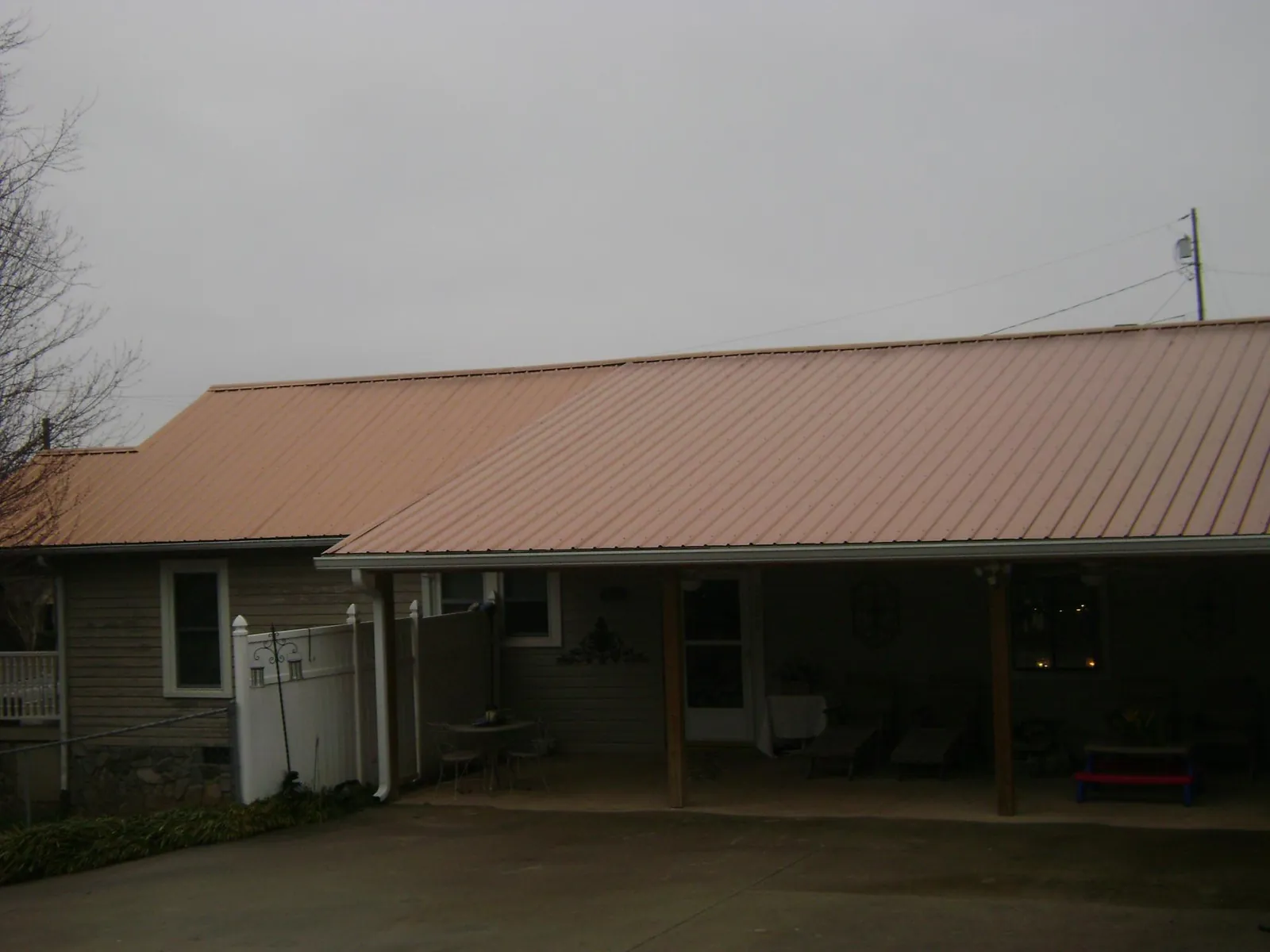 Copper toned metal roof over a wide covered patio in Roscoe